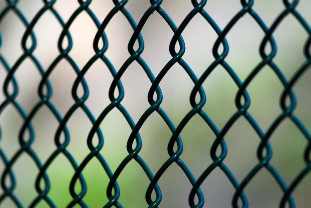 A close up of a green chain link fence on an angle.