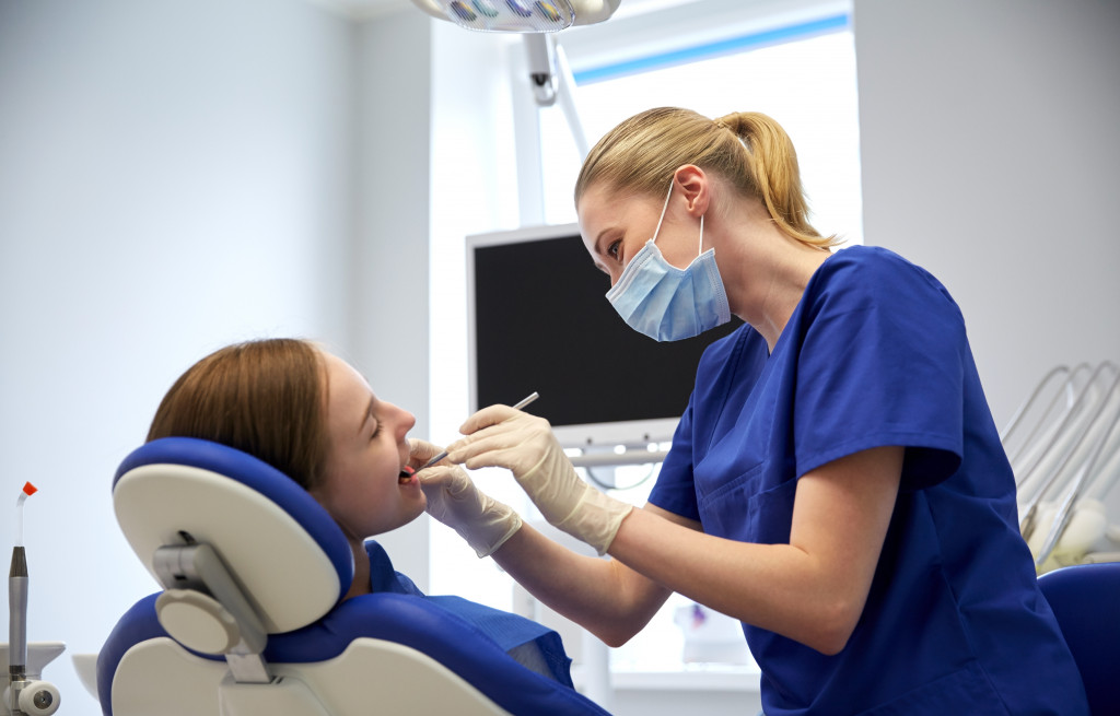 A girl having her dental health checked by a dentist in a dental clinic