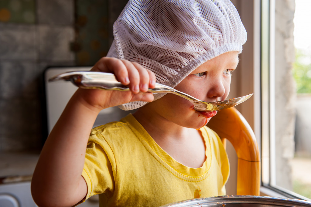 A kid cooks using child-friendly kitchen supplies