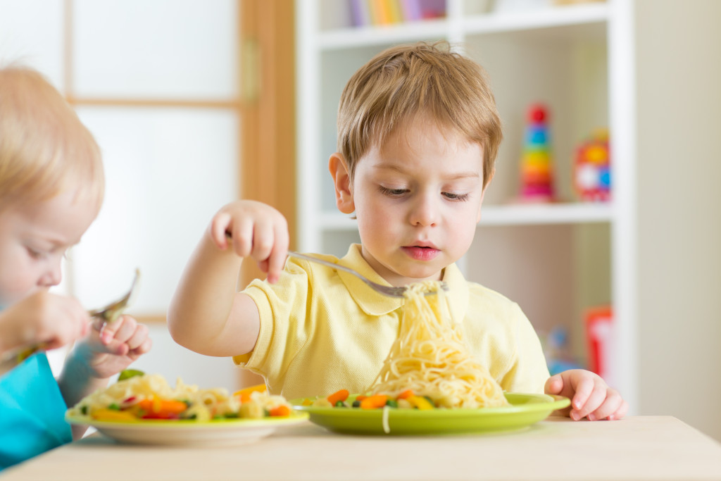 Two kids eating healthy food from plate