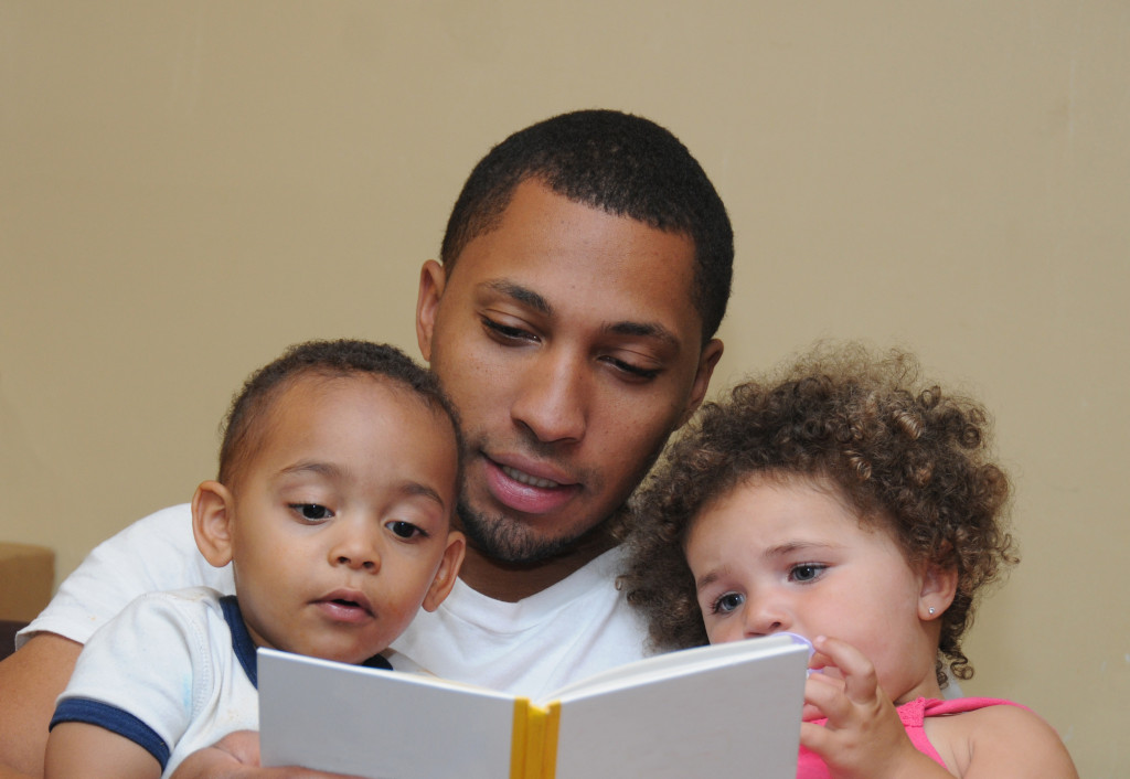 Father reading a story with his two children.