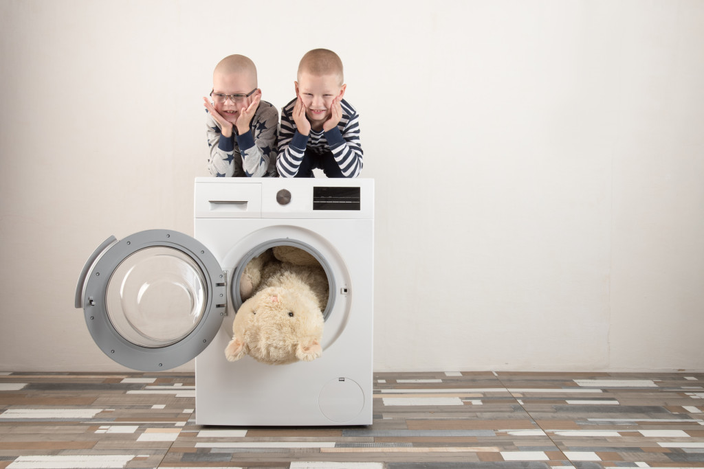 Kids playing on top of the laundry machine