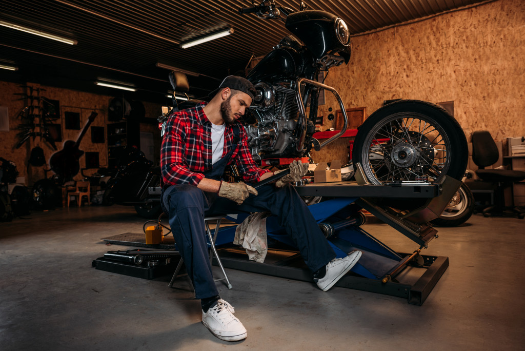 Young man working on his bike in home garage