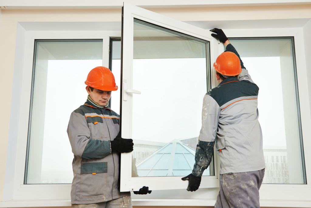 Two male industrial workers installing windows