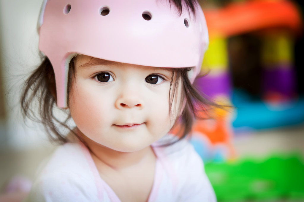 Toddler wearing a safety helmet while playing.