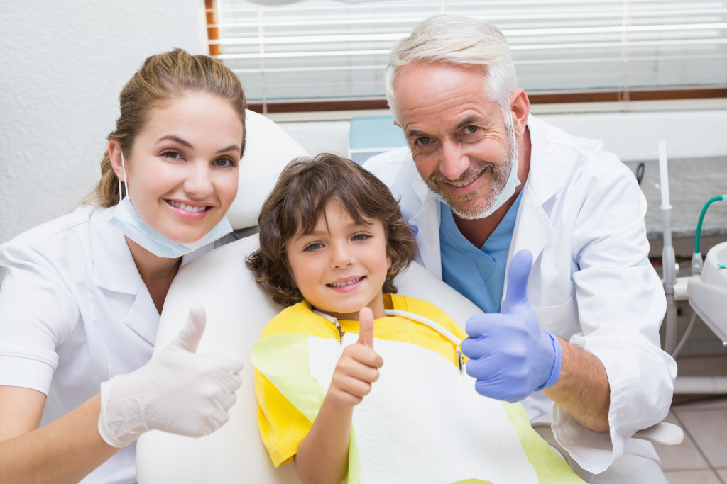 dental patient thumbs up with dentists