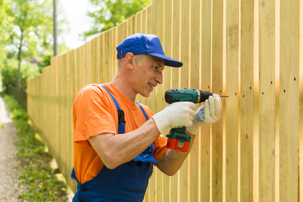 man installing wood fence
