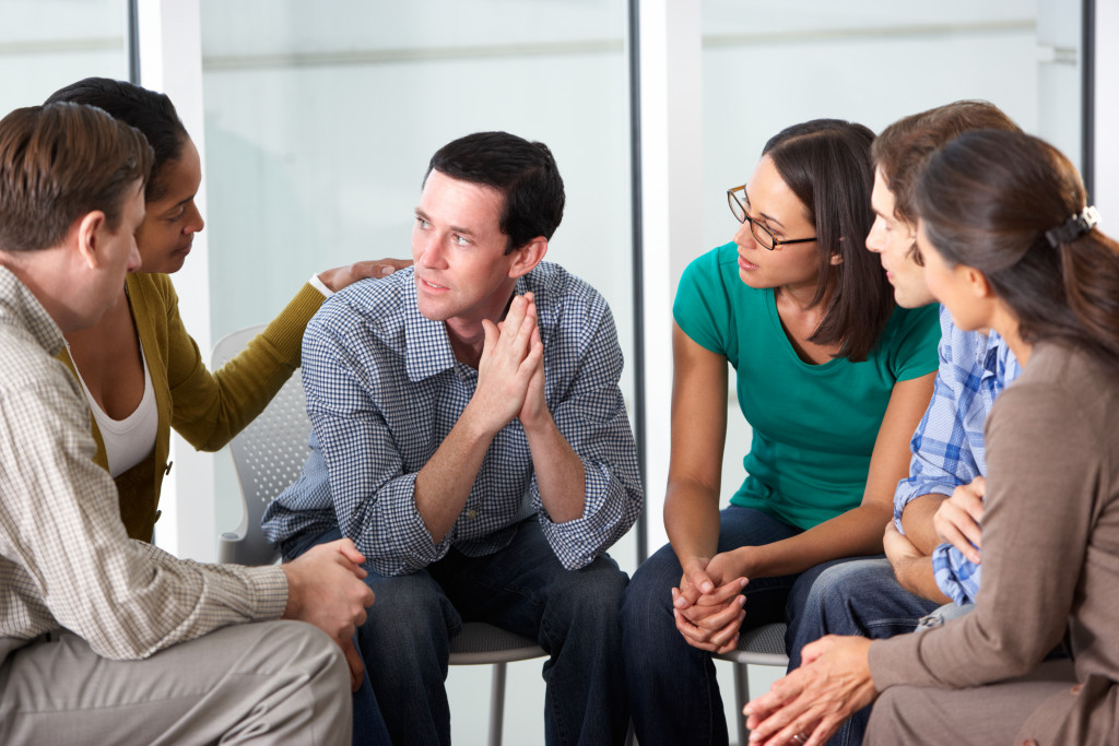 man being comforted in support group