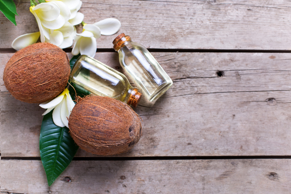 Coconuts, flowers, and bottles on a wood floor